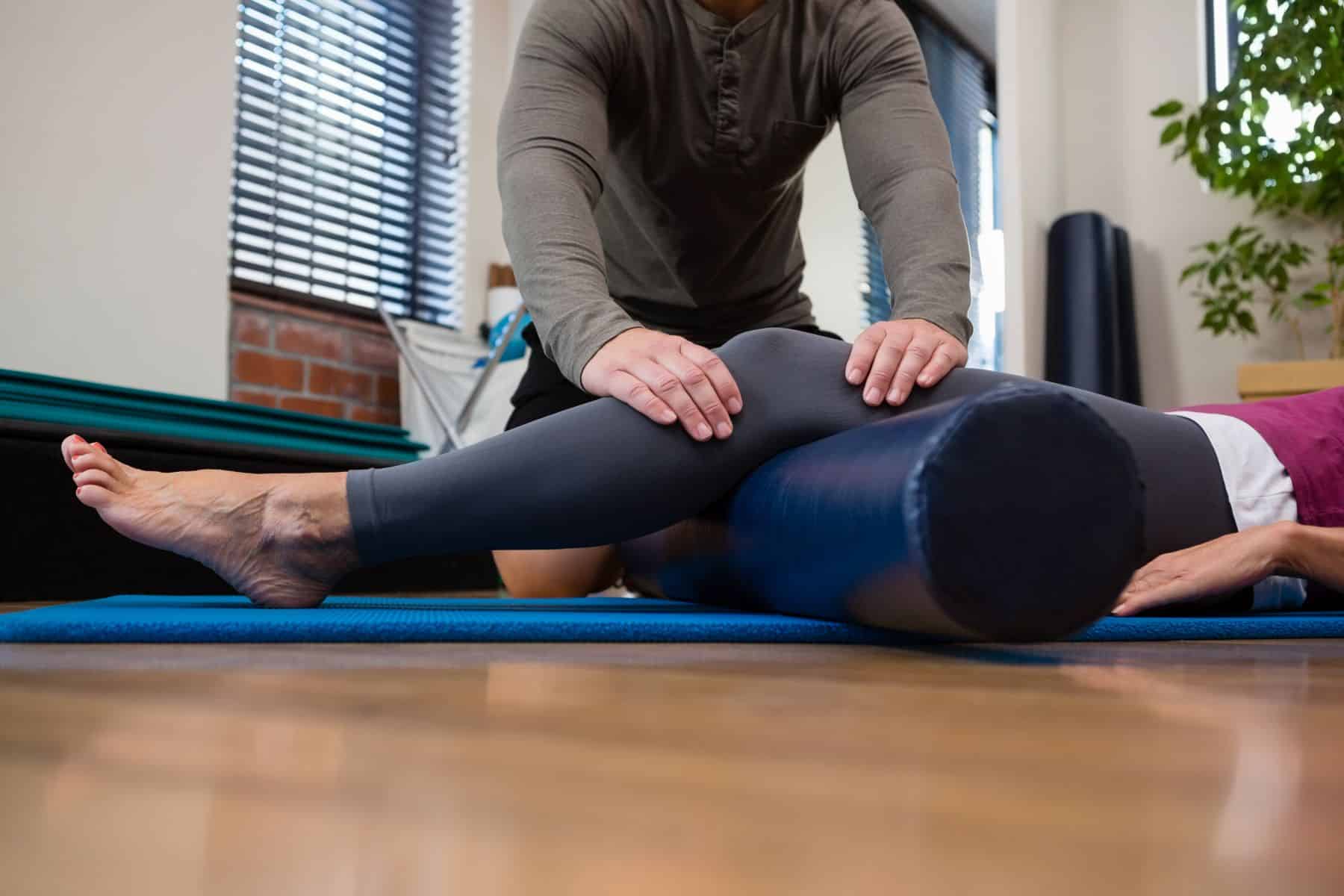 cropped image of a chiropractor adjusting a patient's knee