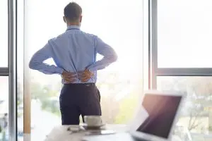 man suffering from muscle spasm while working
