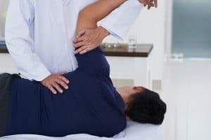 The doctor giving back pain  treatment for patient 