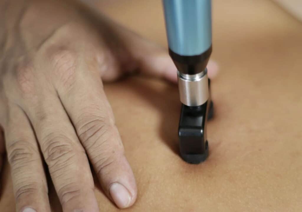 Close-up of an Activator adjusting instrument on a patient's back
