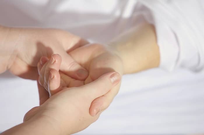 Chiropractor massaging a patient's hand