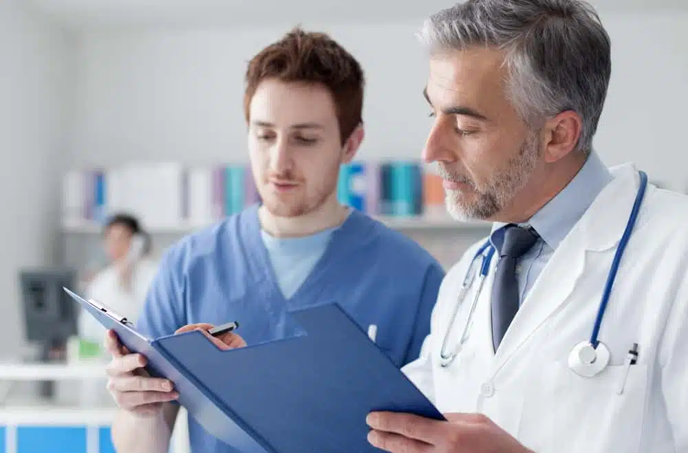 The male doctor and nurse looking at a clipboard at Woodlands, TX