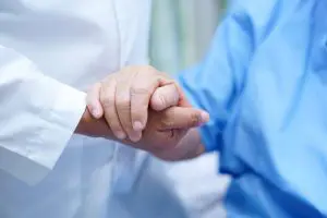 Patient and doctor holding hands after a pain management procedure