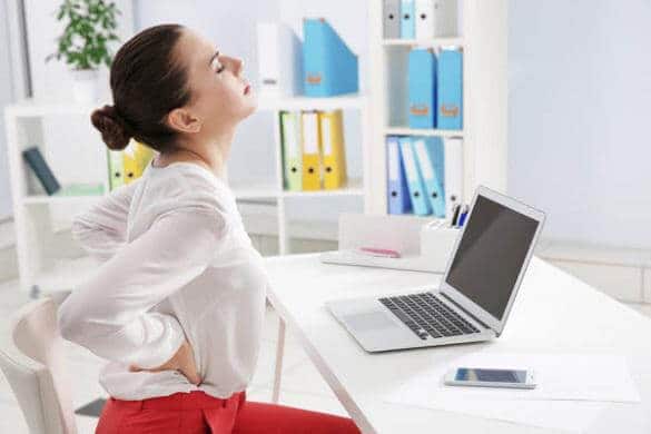 A women having a back pain while working in the office