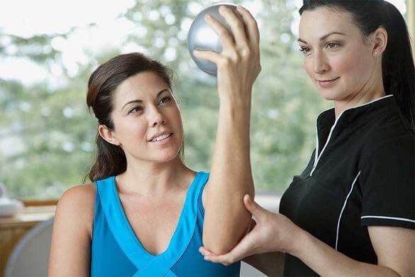 A nurse assisting her patient for a exercise session