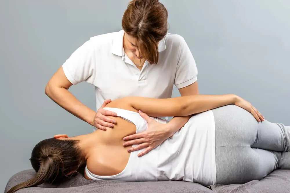 female chiropractor adjusting a female patient's back by cox technique