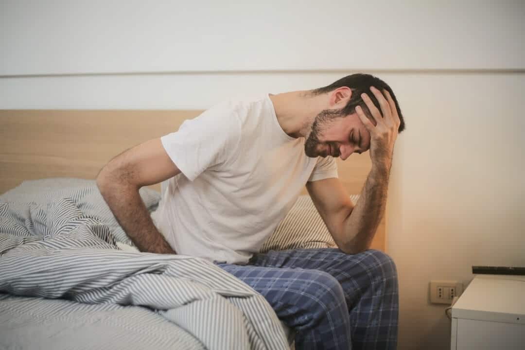 man having a headache from waking up