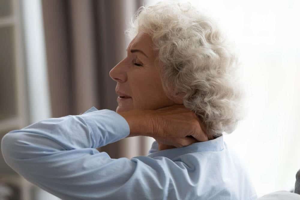 female senior massaging her neck in pain