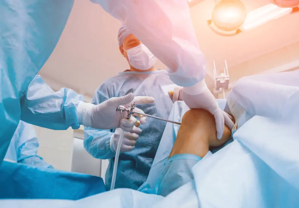 low angle shot of a leg surgery with doctors operating
