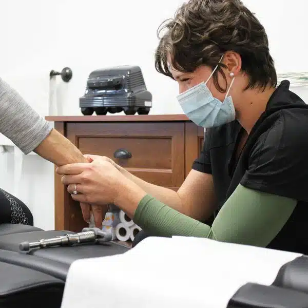 female chiropractor treating hand pain on a patient[lands and Houston