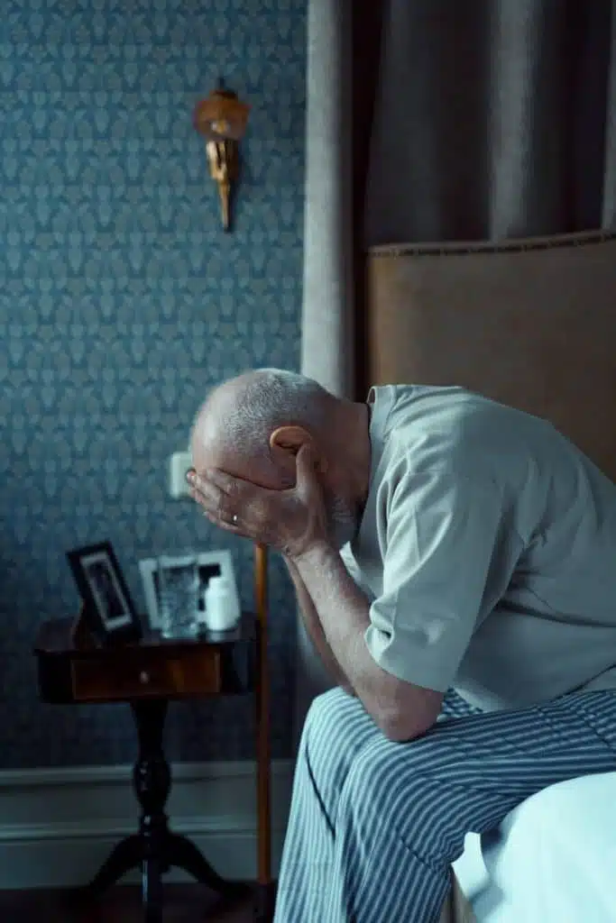 old man holding his head from headache pain