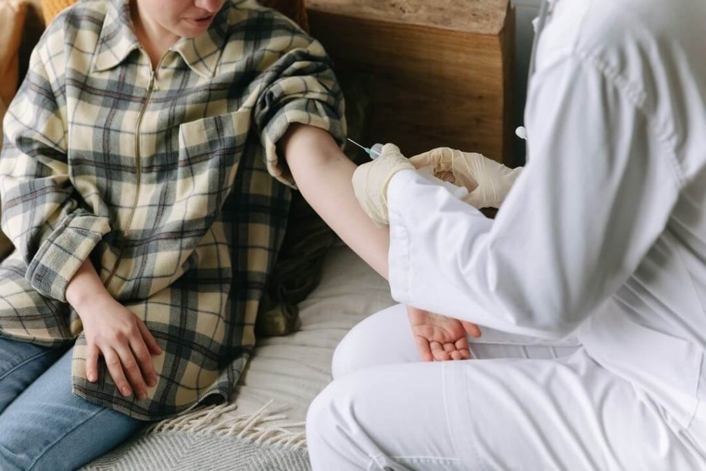 doctor about to give joint injection to a male patient with his left arm stretched out