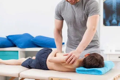 Young patient having pediatric chiropractic treatment in rehabilitation center