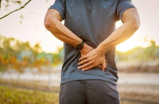 man suffering from back pain during outdoor exercise