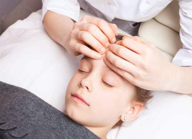 chiropractor is doing some Optimal nerve and brain function assessment to a child patient