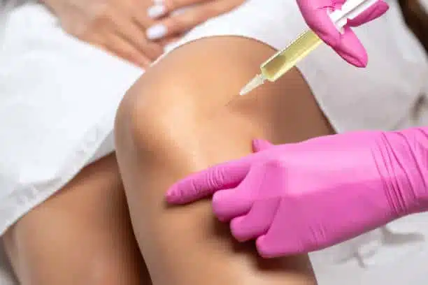 Doctor doing some stem cell therapy regenerative medicine to the patients knee