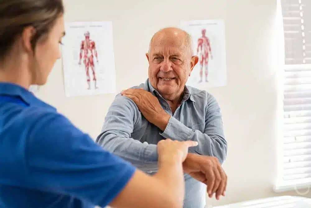 Male doctor chiropractor doing some chiropractic adjustment to the senior patient.
