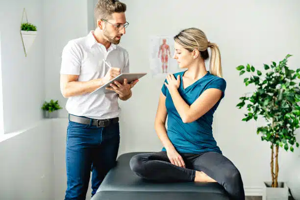 Chiropractor is having a chiropractic evaluation with a woman patient.