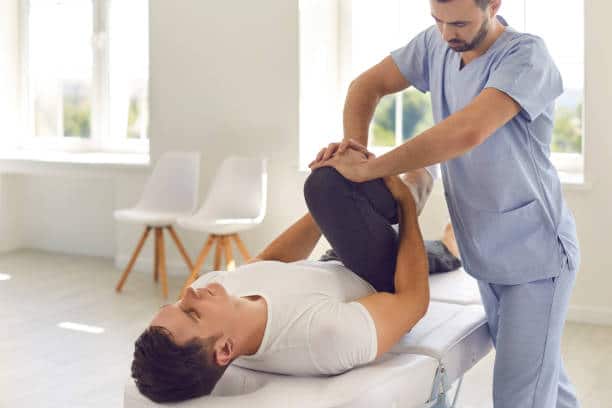 Physiotherapist helping a senior patient with his physical therapy treatment.