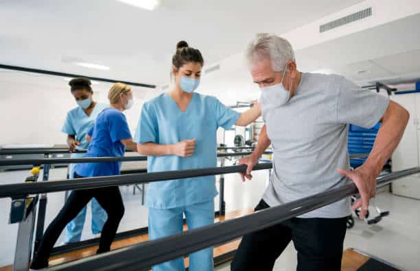 Group of Physiotherapist and patients doing physical therapy exercises at the rehabilitation center.