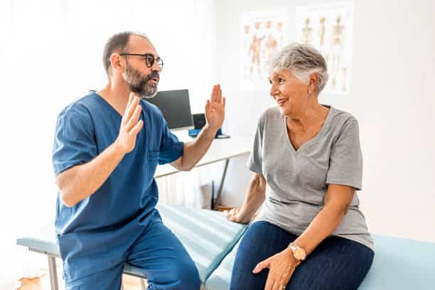 Chiropractor is having a chiropractic evaluation with a senior patient.