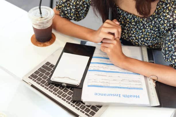 Patient filling in her health insurance information before going to the chiropractic evaluation.