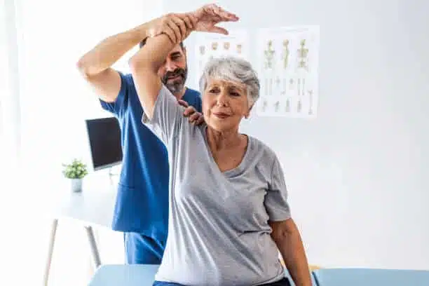 Male doctor chiropractor doing some chiropractic adjustment to the senior patient.