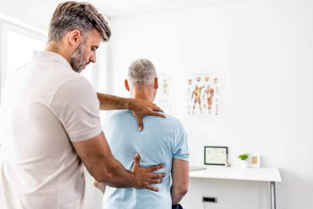 Male doctor chiropractor doing some chiropractic adjustment to the senior patient.
