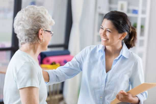 Female doctor talks with new patient before beginning treatment.