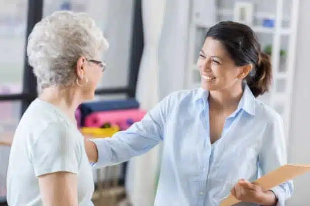 Female chiropractor talks with new patient before beginning treatment.