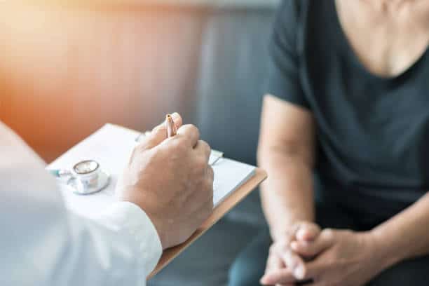 Chiropractor is having a chiropractic evaluation with a woman patient.