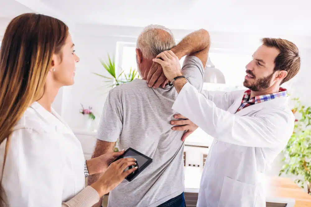 Chiropractor is having a chiropractic evaluation with a senior patient.