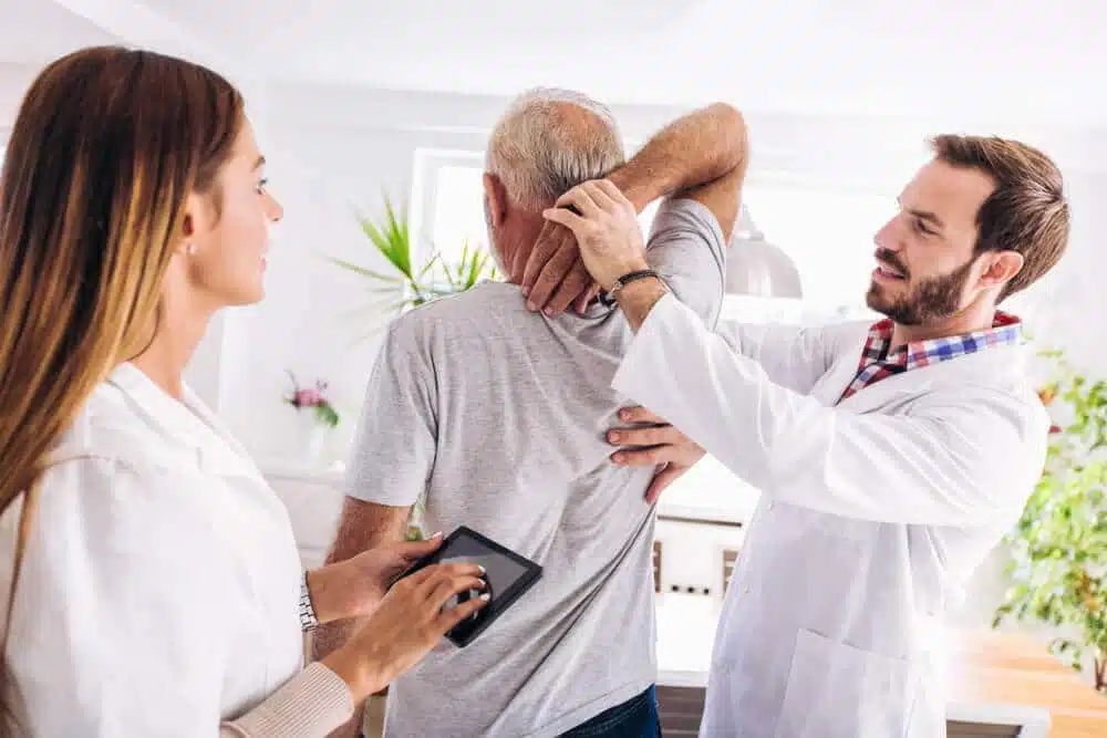 Chiropractor is having a chiropractic evaluation with a senior patient.