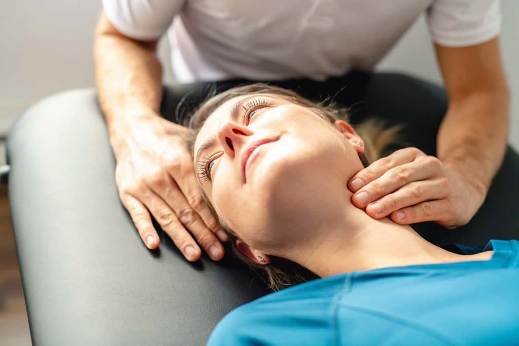 Chiropractor doing some chiropractic adjustment to the patient's neck.