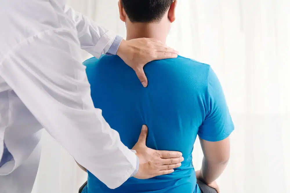 Chiropractor is having a chiropractic evaluation with a man patient.