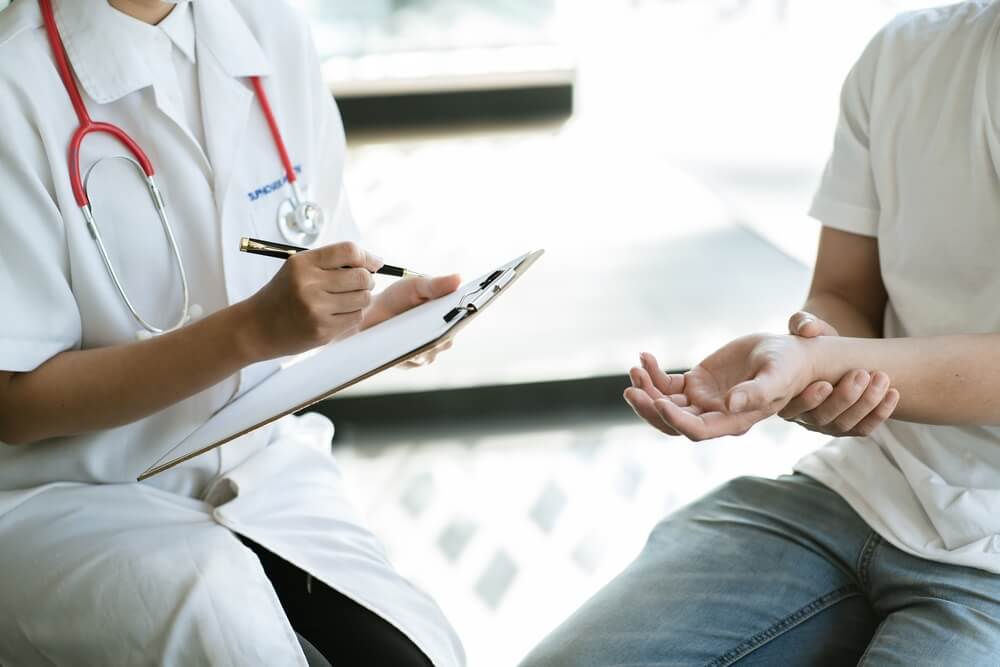 Chiropractor is having a chiropractic evaluation with a patient, explaining the insurance coverage.c