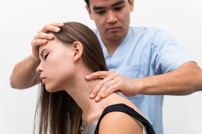 A closeup of a chiropractor providing neck pain treatment to a female patient.