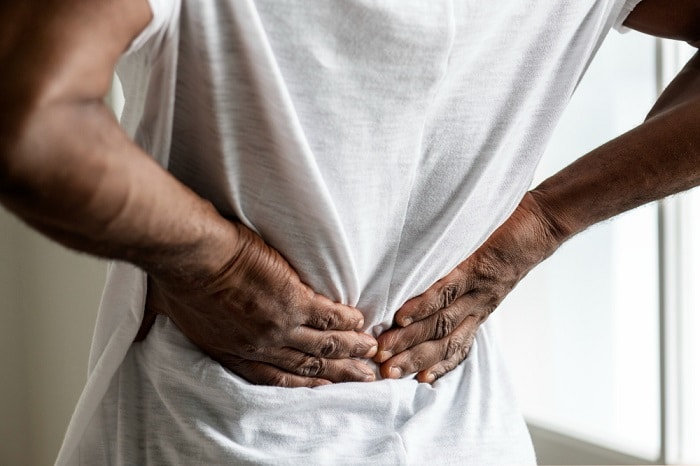  An image of a man experiencing back pain seeking treatment in The Woodlands.