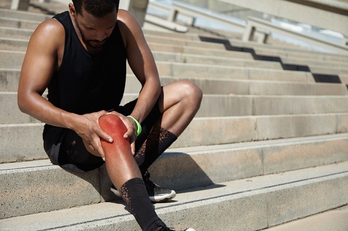 young man with suffering form joint pain due to a knee injury
