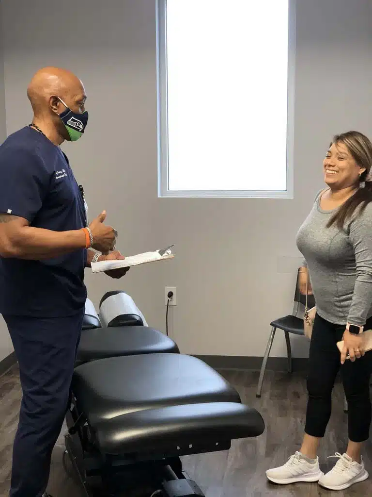 Chiropractor having an chiropractic evaluation with a patient at Houston Spine and Rehab.