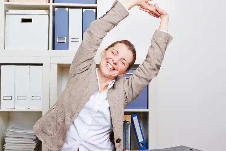 Office woman stretching her back feeling happy.