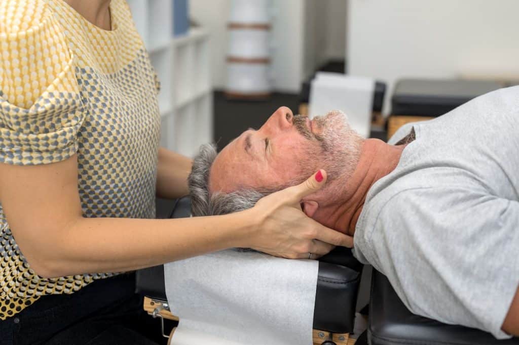 Chiropractor doing some chiropractic neck adjustment to the patient.