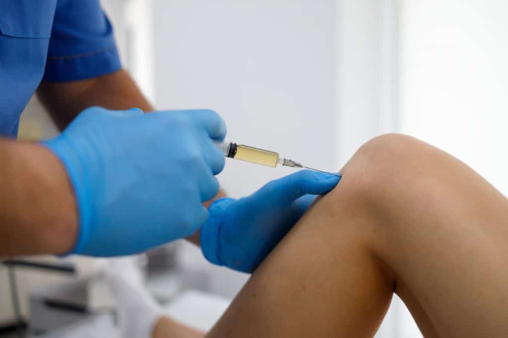 chiropractor doing some joint injection to a patient.