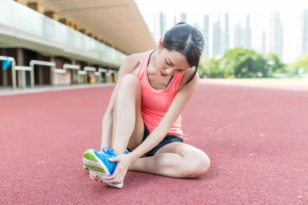 Athlete suffers from foot pain while doing outdoor sports.