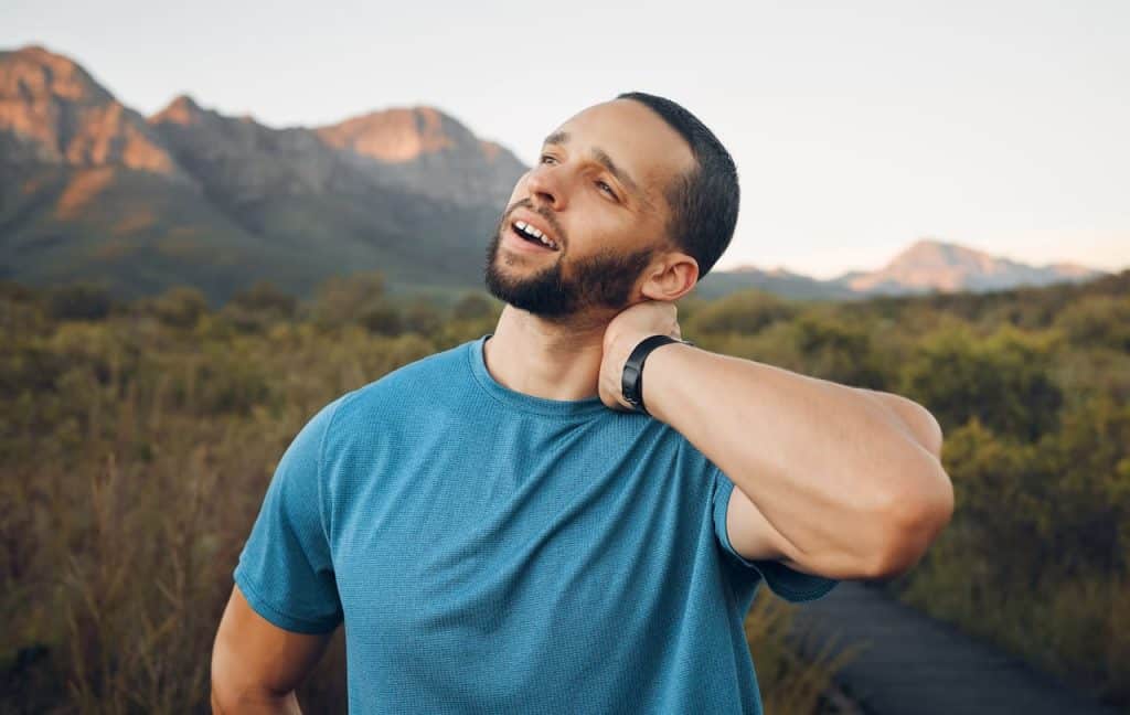 athletic man holding his neck in pain