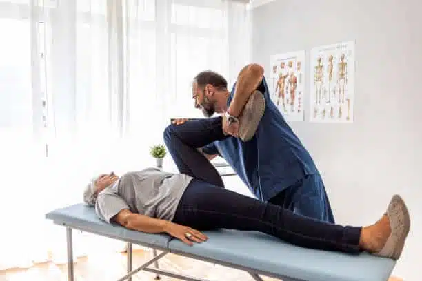 physical therapist doing a stretch on mans leg