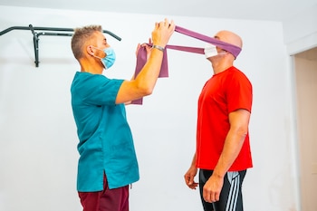 physiotherapist helping patient do a stretch on the neck using rubberband-