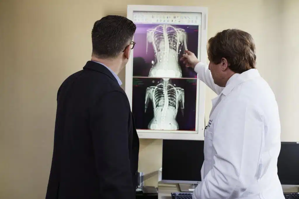 Spine specialist reviewing scoliosis X-rays to develop personalized treatment plan